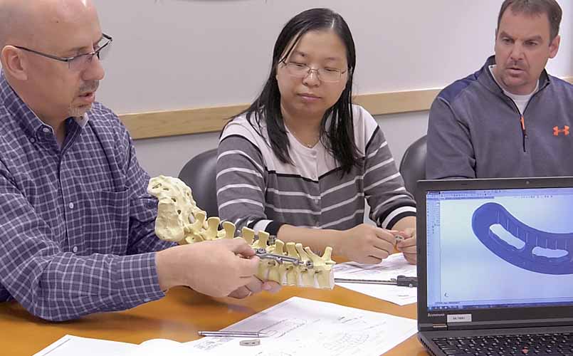 Engineering team review spinal implant prototype
